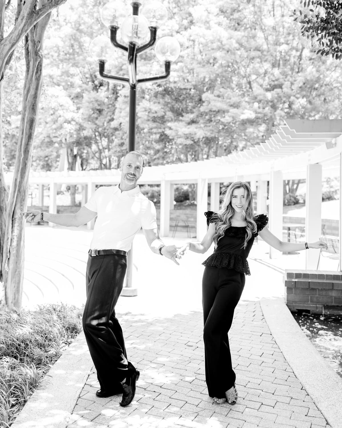 Myers and Steve dancing together outdoors, holding hands mid-step